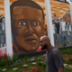 People walk past a mural of Freddie Gray on June 23, 2016, in Baltimore.
Mark Makela/Getty Images